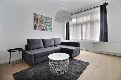 a living room with a couch and a table at Rent a Flat - Bruxelles in Brussels