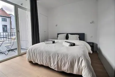 a bedroom with a large bed and a large window at Rent a Flat - Bruxelles in Brussels