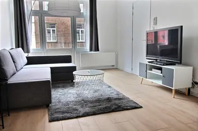 a living room with a couch and a flat screen tv at Rent a Flat - Bruxelles in Brussels