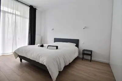 a bedroom with a large bed and a large window at Rent a Flat - Bruxelles in Brussels