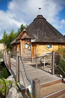 a wooden cabin with a bench on a wooden deck at Hotel Thermen Dilbeek in Dilbeek