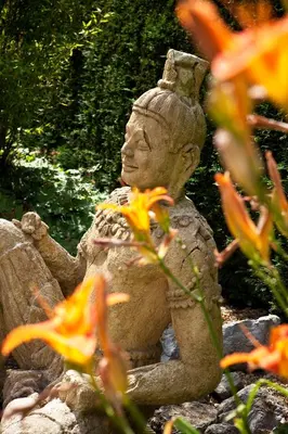 a statue of a person sitting in a garden at Hotel Thermen Dilbeek in Dilbeek