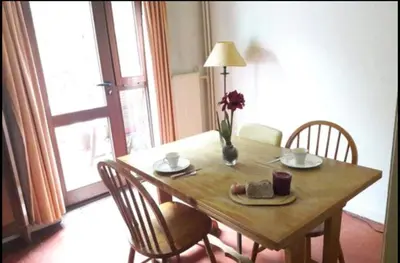 a wooden table with a vase of flowers on it at Chez Mimi - chambre vue parc in Brussels