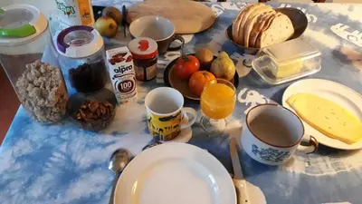 a table topped with cups and plates of food at Chez Mimi - chambre vue parc in Brussels