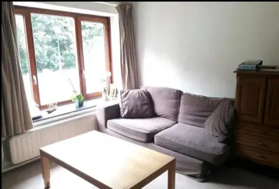 a living room with a couch and a coffee table at Chez Mimi - chambre vue parc in Brussels