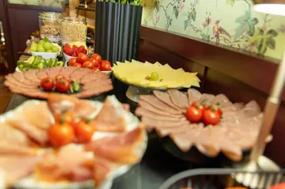 a buffet with plates of food with tomatoes on them at Hotel Rubenshof in Antwerp
