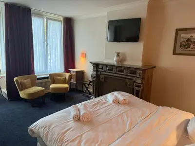a hotel room with a bed with slippers on it at Hotel Rubenshof in Antwerp