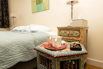 a bed with a table with a plate of food on it at Hotel De Pastorij in Leuven
