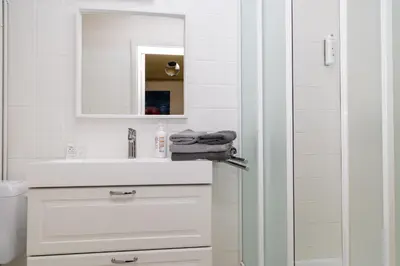 a white bathroom with a sink and a mirror at Hotel De Pastorij in Leuven