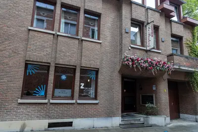 a brick building with flowers in the windows at Hotel De Pastorij in Leuven