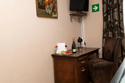 a room with a table with a bottle of wine and a chair at Hotel De Pastorij in Leuven