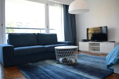 a living room with a blue couch and a tv at Florya Studio Woluwe in Brussels