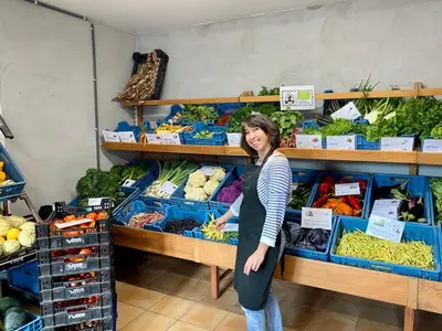 a woman standing in a produce section of a store at Hof ter Dreef in Meise