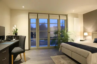 a bedroom with a bed and a desk with a desk at Hof ter Dreef in Meise