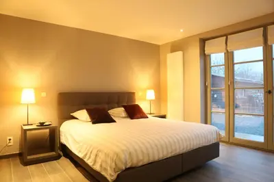a bedroom with a large bed and a window at Hof ter Dreef in Meise