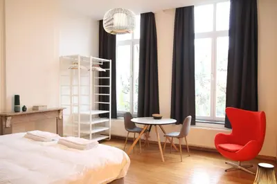 a bedroom with a bed and a table and chairs at Hoogpoort Residence George in Ghent