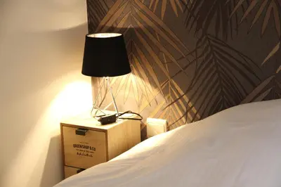 a lamp sitting on a box next to a bed at Hoogpoort Residence George in Ghent