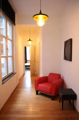 a living room with a red couch and a window at Hoogpoort Residence George in Ghent