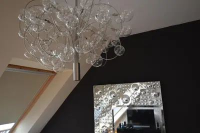 a chandelier hanging from a ceiling next to a mirror at Ars Vivendi in Moerbeke