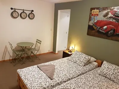 a bedroom with a bed and a table and a bike on the wall at Brigitte & Alain in Brussels