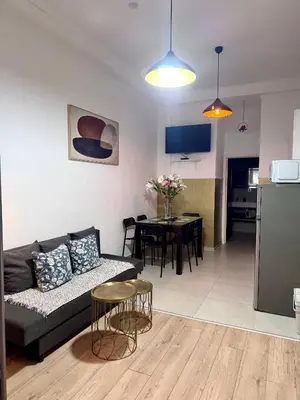 a living room with a black couch and a kitchen at Sint-Jans Appartments in Antwerp