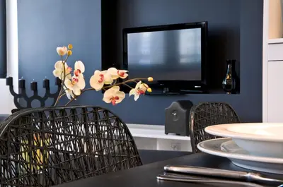 a dining room with a table with two chairs and a tv at B-aparthotel Regent in Brussels