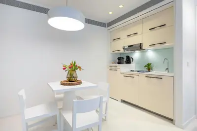 a kitchen with white cabinets and a white table and chairs at B-aparthotel Regent in Brussels