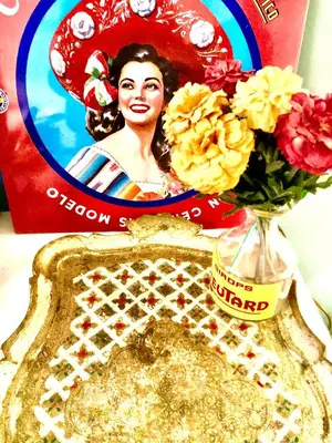 a table with a vase of flowers and a picture of a woman at Foodiejive in Antwerp