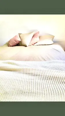 a white bed with two pillows on top of it at Foodiejive in Antwerp