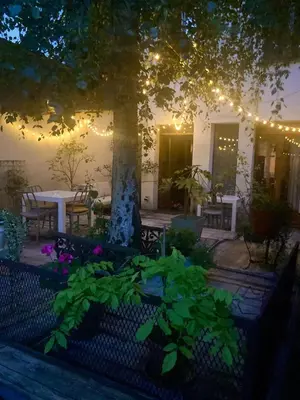 a patio with a table and a tree with lights at Foodiejive in Antwerp