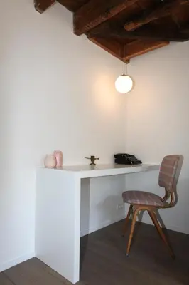 a white desk with a chair and a lamp at Coeur Sablon in Brussels