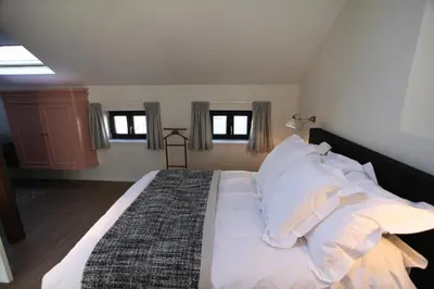 a bedroom with a large bed with white sheets and pillows at Coeur Sablon in Brussels