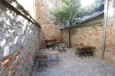 a patio with tables and chairs and a brick wall at Coeur Sablon in Brussels