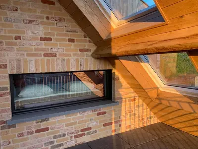 a brick wall with a fireplace in a house at Vakantiewoning 't Rysselhof in Kaprijke
