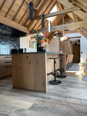 a kitchen with a island in a room with wooden ceilings at Vakantiewoning 't Rysselhof in Kaprijke