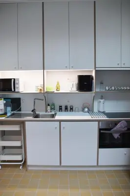 a kitchen with white cabinets and a sink at Antwerp old town appartment in Antwerp