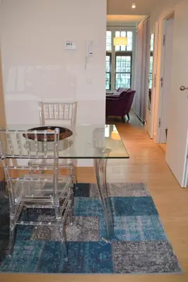 a glass dining room table with two chairs on a rug at Antwerp old town appartment in Antwerp