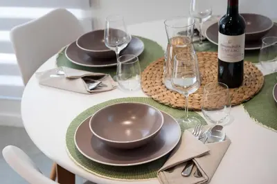 a table with plates and glasses and a bottle of wine at Studio Brussels Airport - Central in Zaventem