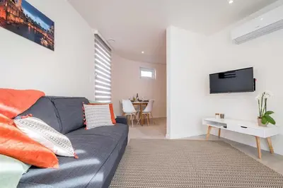 a living room with a gray couch and a tv at Studio Brussels Airport - Central in Zaventem