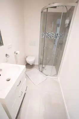 a white bathroom with a shower and a toilet at Studio Brussels Airport - EU-District in Zaventem
