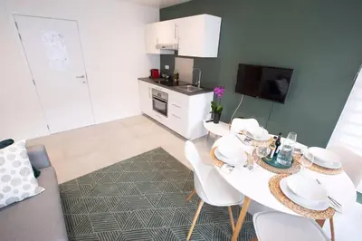 a kitchen with a table and white chairs in a room at Studio Brussels Airport - EU-District in Zaventem