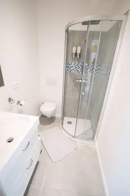 a white bathroom with a shower and a toilet at Studio Brussels Airport - South in Zaventem