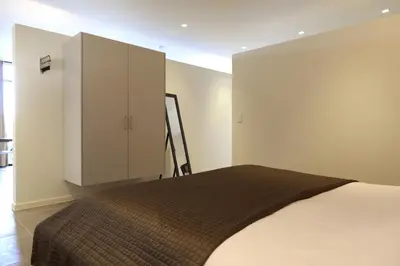 a bedroom with a bed and a white cabinet at Logies De Hessie in Turnhout