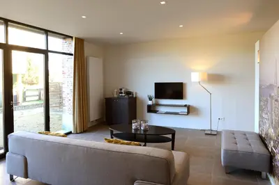 a living room with a couch and a table at Logies De Hessie in Turnhout