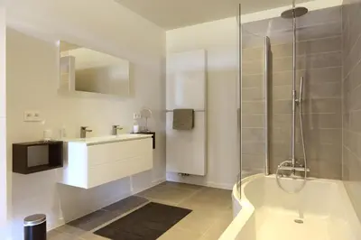 a bathroom with a tub and a sink and a shower at Logies De Hessie in Turnhout