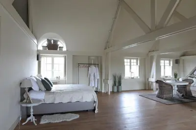 a bedroom with a bed and a table and chairs at The Loft in Melsele