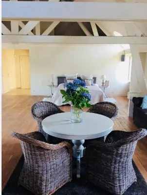 a table with chairs and a vase of flowers on it at The Loft in Melsele