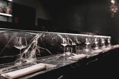 a row of wine glasses and napkins on a counter at Hotel Riga in Antwerp