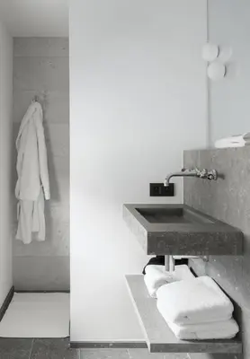 a bathroom with a sink and towels on a shelf at Hotel Riga in Antwerp