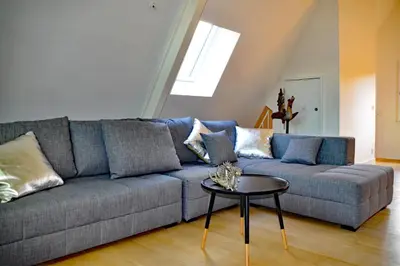 a living room with a blue couch and a table at Antwerp old town triplex apartment in Antwerp